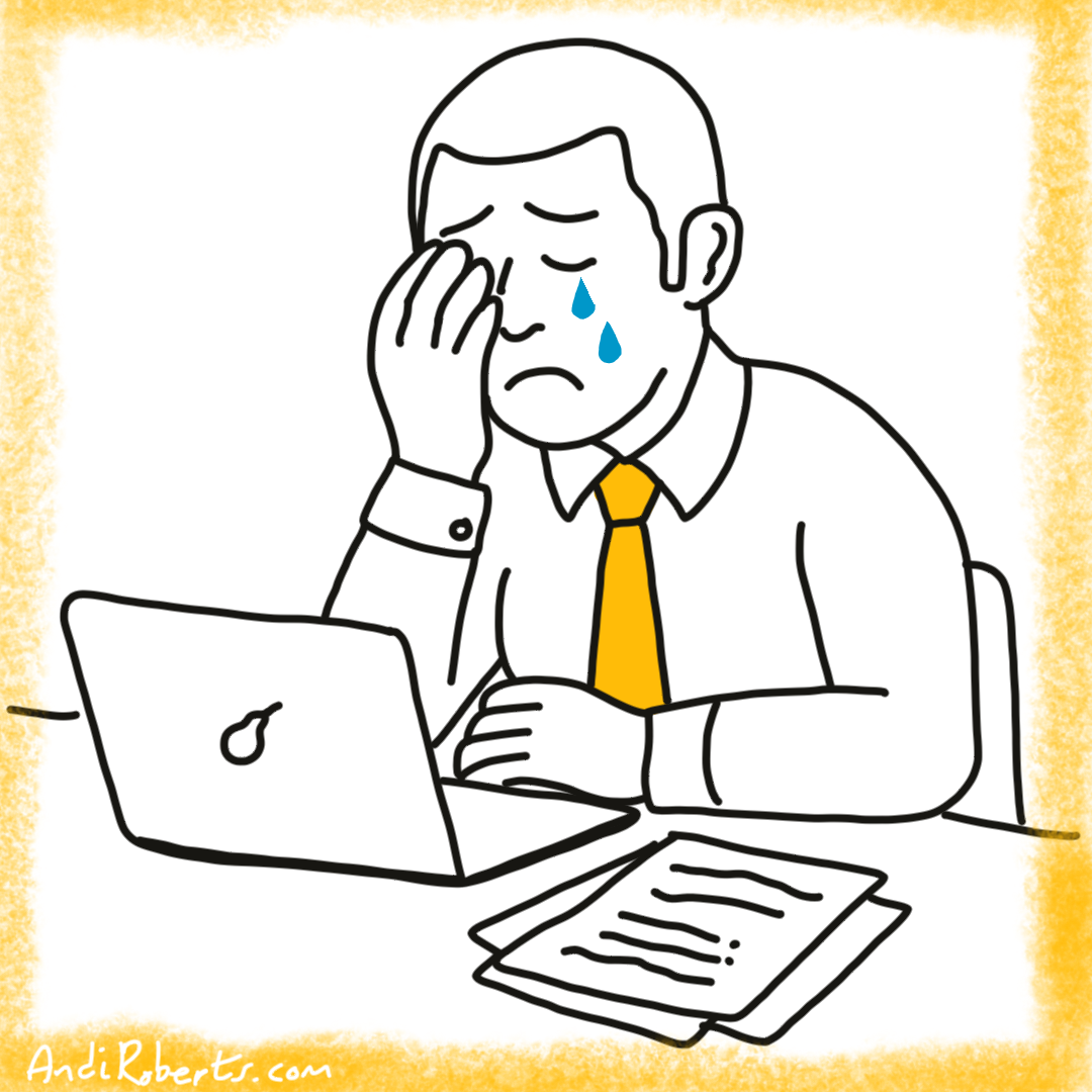Male person at their desk, with hand on face crying